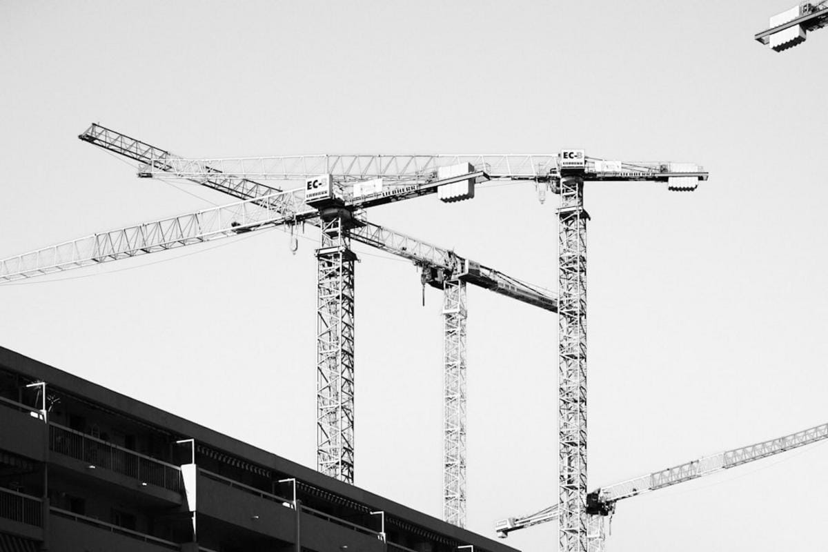 A construction site featuring a modern, fully automated ready-mix plant with safety features being monitored